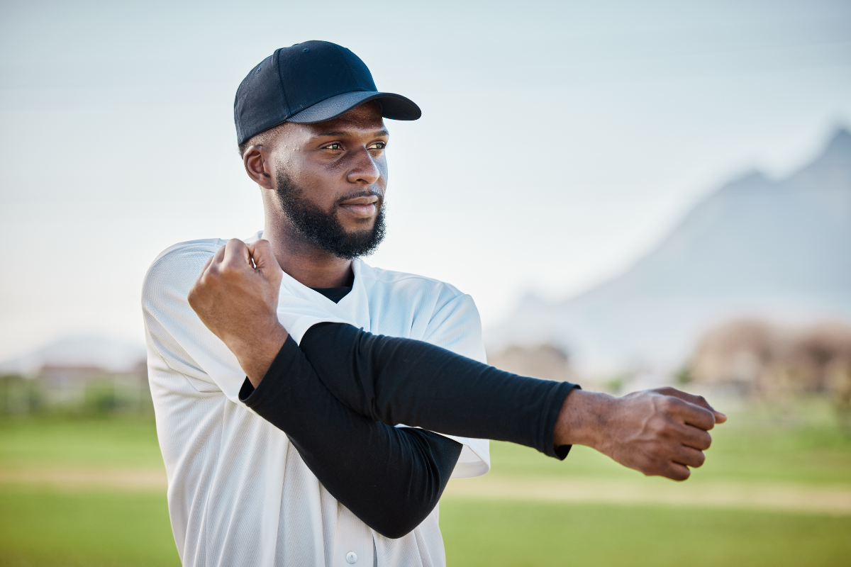 A baseball player stretching his shoulder in Texas.