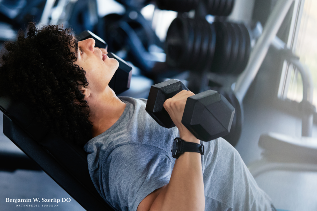 A man performing a chest press exercise with dumbbells to strengthen his pectoralis muscle in Texas.